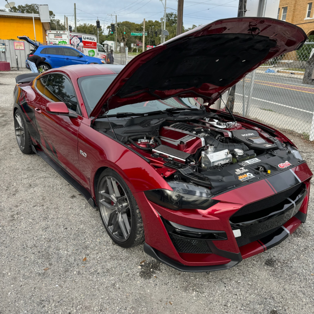 Red Ford Mustang GT getting washed at Island Shine Auto Wash, using eco-friendly self-service equipment in V.M. Ybor, Tampa.